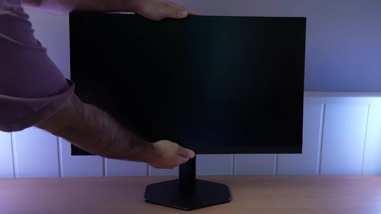 Persona ajustando el monitor AOC Q27G4XF sobre la peana
