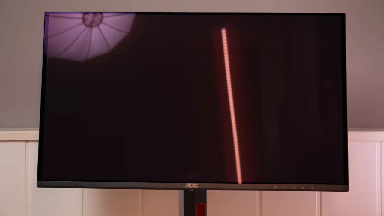 Primer plano del AOC Q27G4ZDR mostrando una línea de prueba vertical sobre fondo oscuro