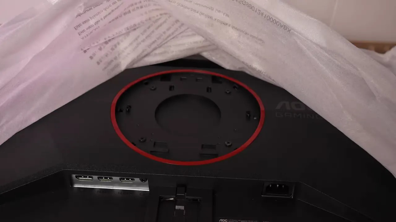 Puertos traseros del monitor AOC Q27G4ZE con tapas y conexiones principales visibles