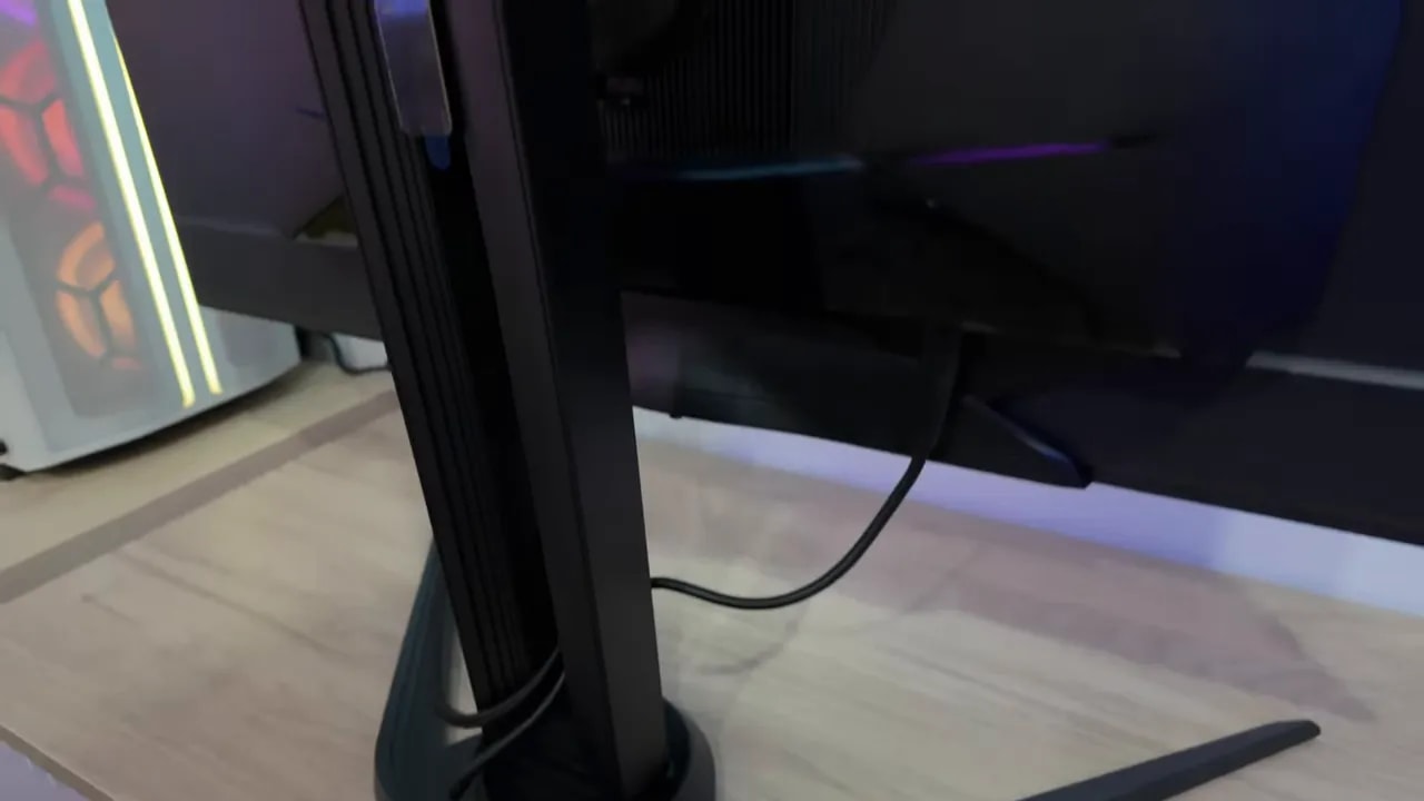 Vista de la peana del monitor AORUS FO32U2P y un cable conectado sobre la mesa