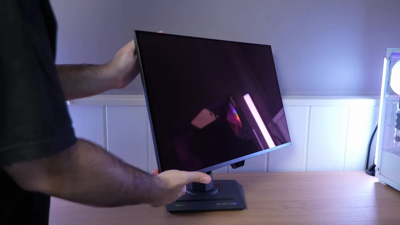 Persona sujetando el monitor Asus ROG XG27UCDMG sobre la peana en el escritorio