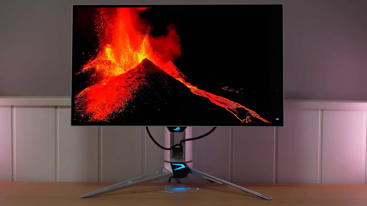 Monitor Asus ROG Swift OLED PG27AQWP-W mostrando una escena con alto contraste sobre soporte trípode