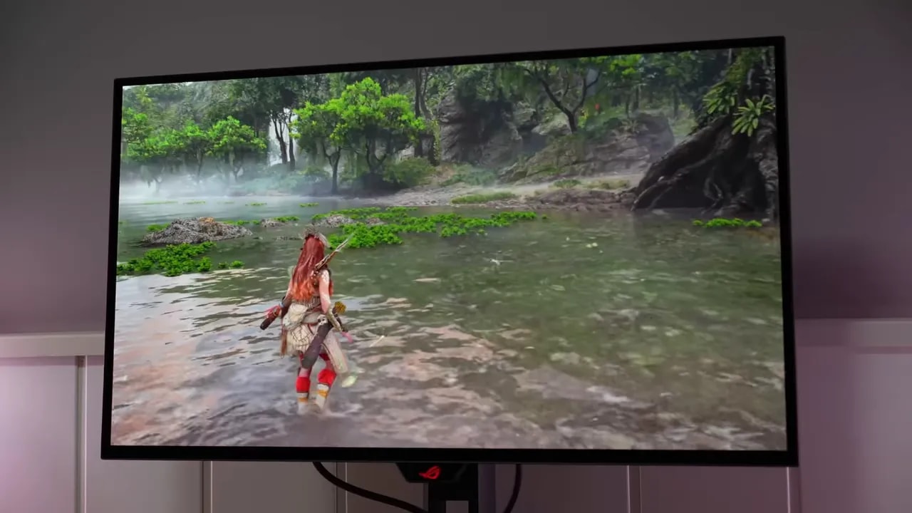Asus ROG XG27AQWMG mostrando una escena de juego con personaje en un río