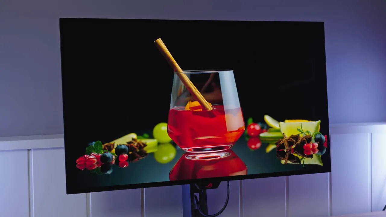 Monitor ASUS ROG XG32UCWMG mostrando una escena con bebida roja y reflejos en pantalla