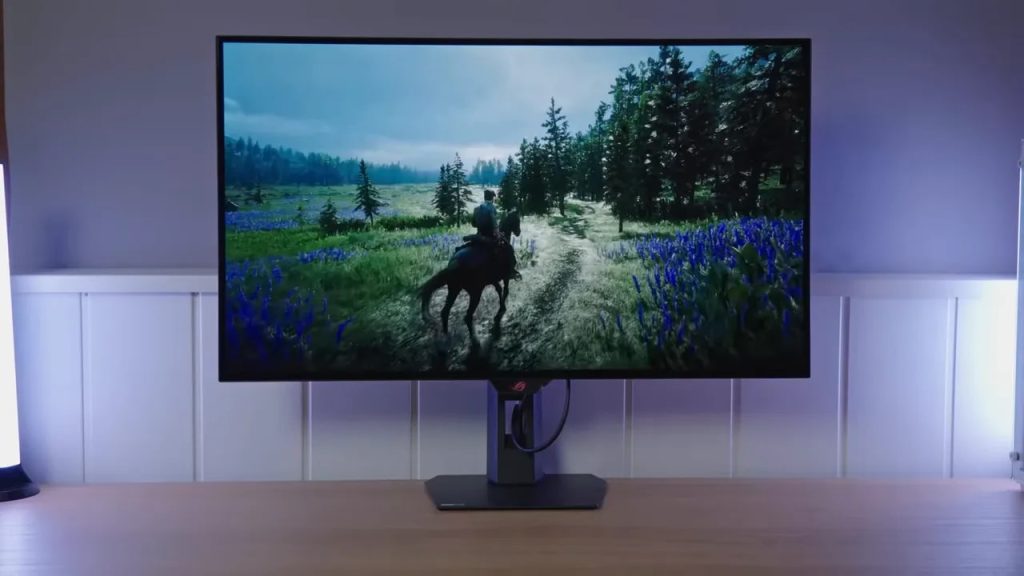 ASUS ROG XG32UCWMG mostrando escena en el monitor OLED 4K glossy en escritorio con luz ambiental