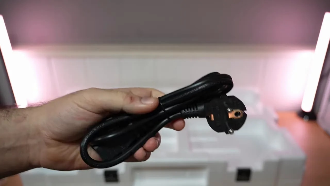 Mano revisando documentación y papeles del Gigabyte MO27Q28G durante el unboxing