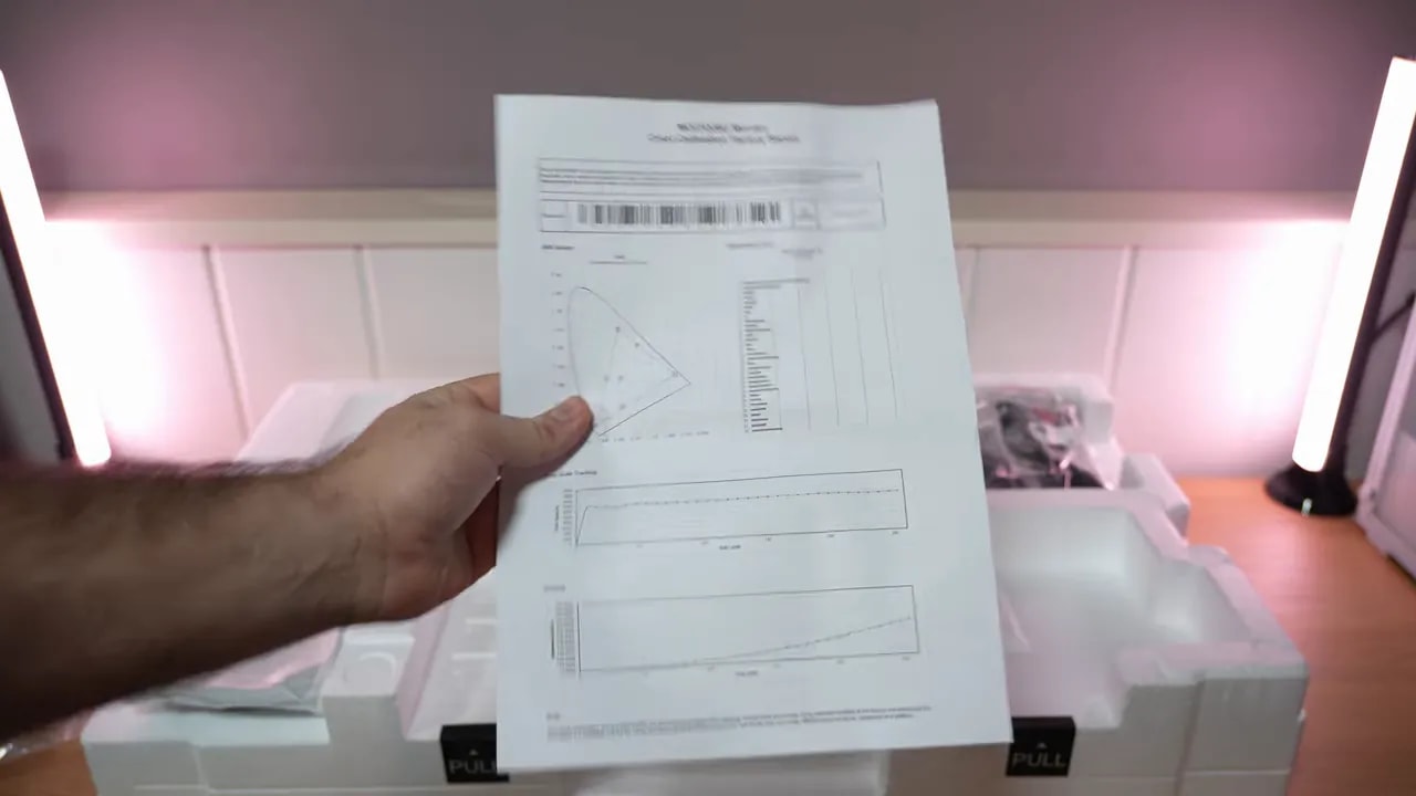 Mano revisando documentación y papeles del Gigabyte MO27Q28G durante el unboxing