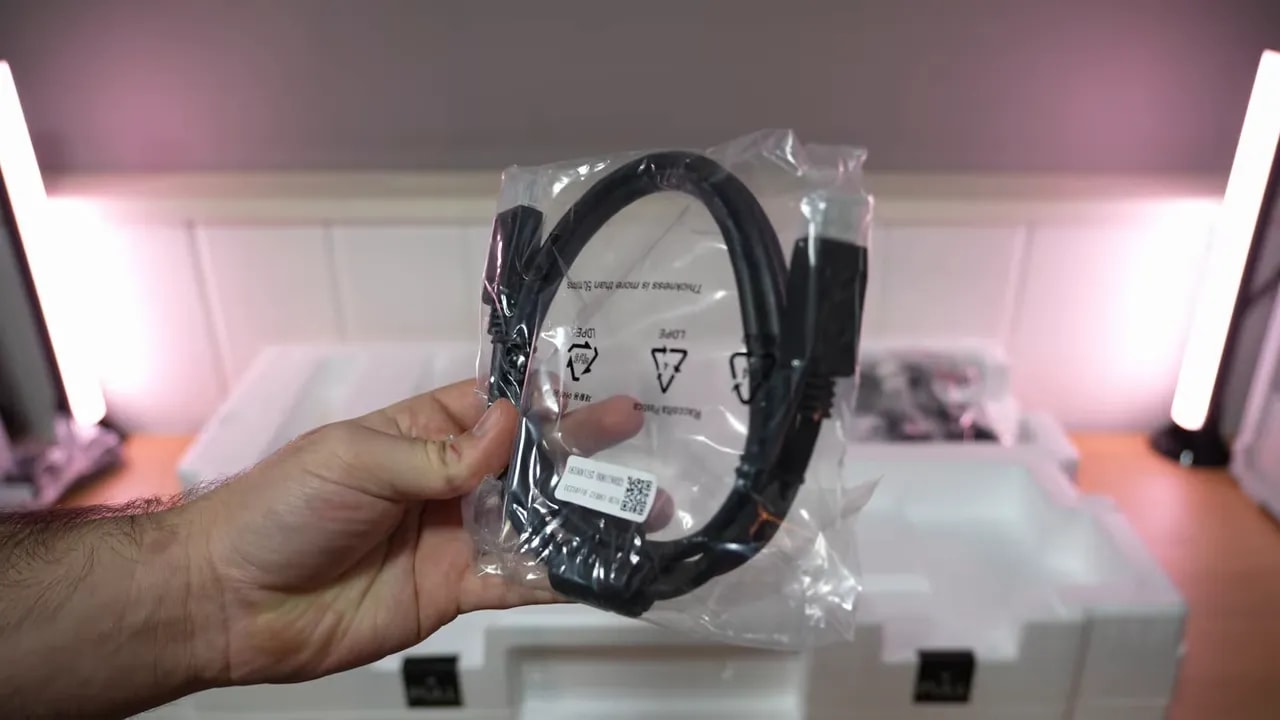 Mano revisando documentación y papeles del Gigabyte MO27Q28G durante el unboxing