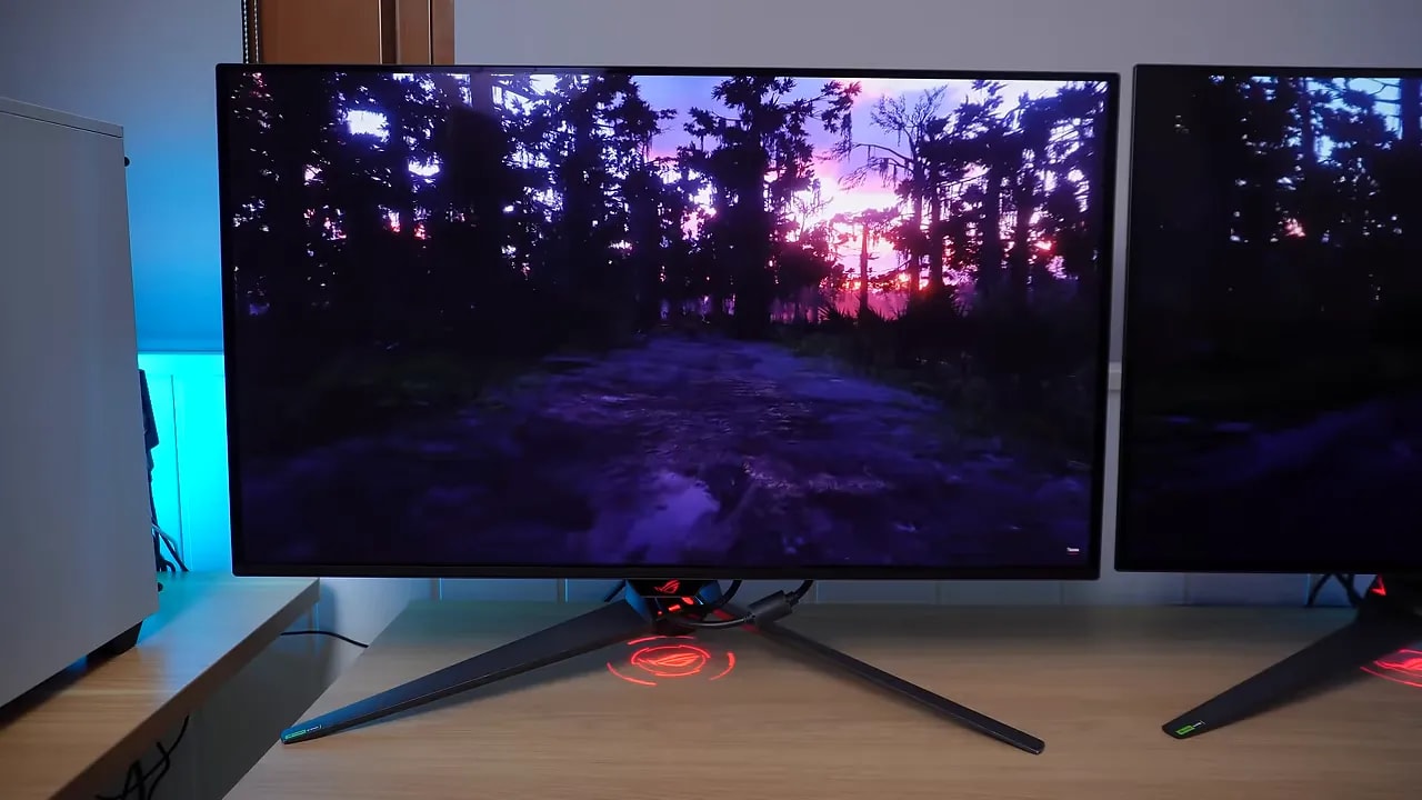 Dos monitores ASUS ROG OLED 32 pulgadas con escena de bosque al atardecer