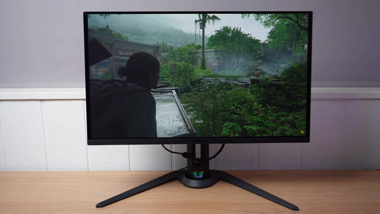 Gigabyte AORUS FO27Q3 en pantalla mostrando una escena de juego con lluvia y vegetación