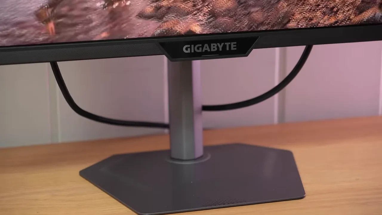 Mano ajustando el soporte del monitor Gigabyte G27Q2 durante el montaje
