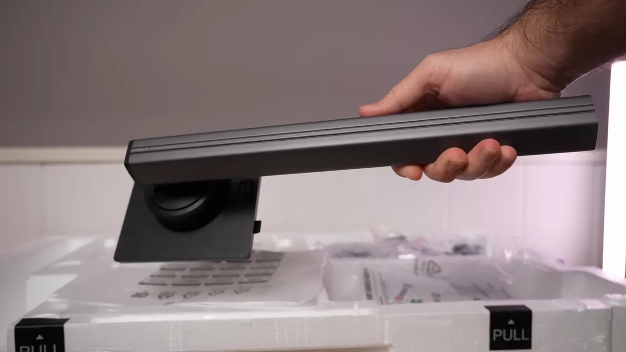 Mano mostrando cables y accesorios del Gigabyte G27Q2 sacados del embalaje