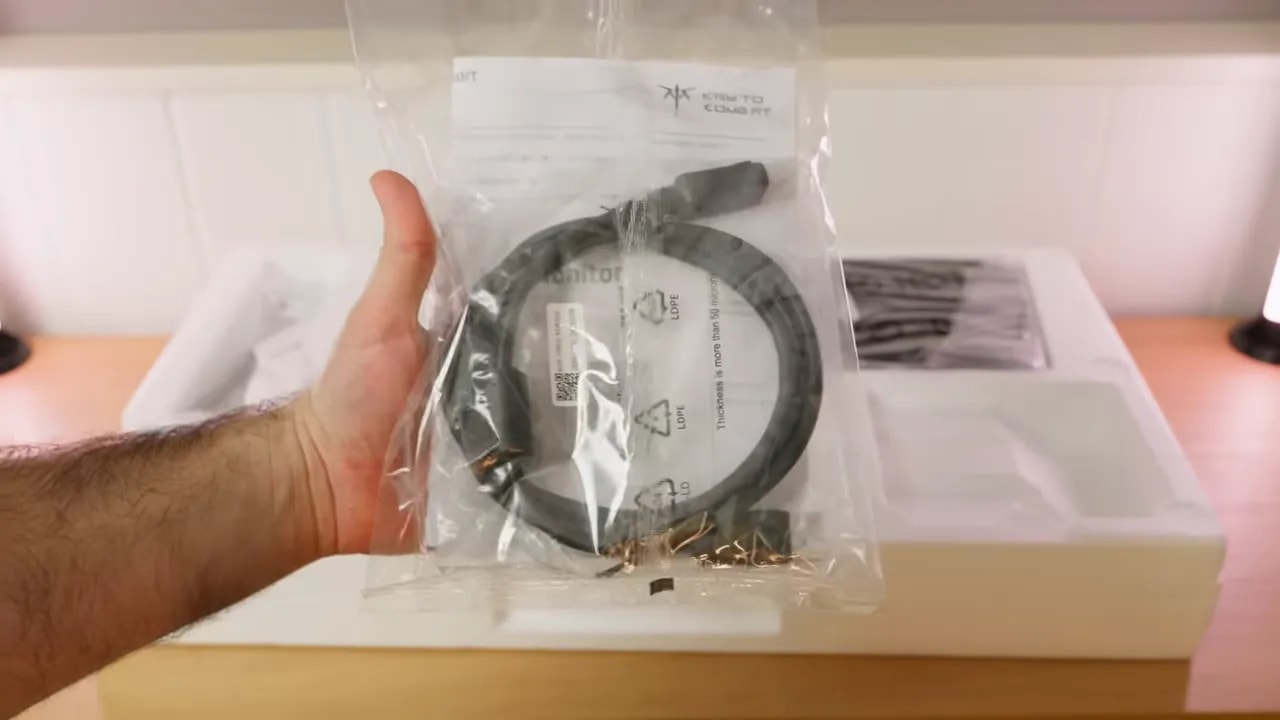Accesorios del KTC H27T7P-2 dentro de la caja, con cables en su envoltorio