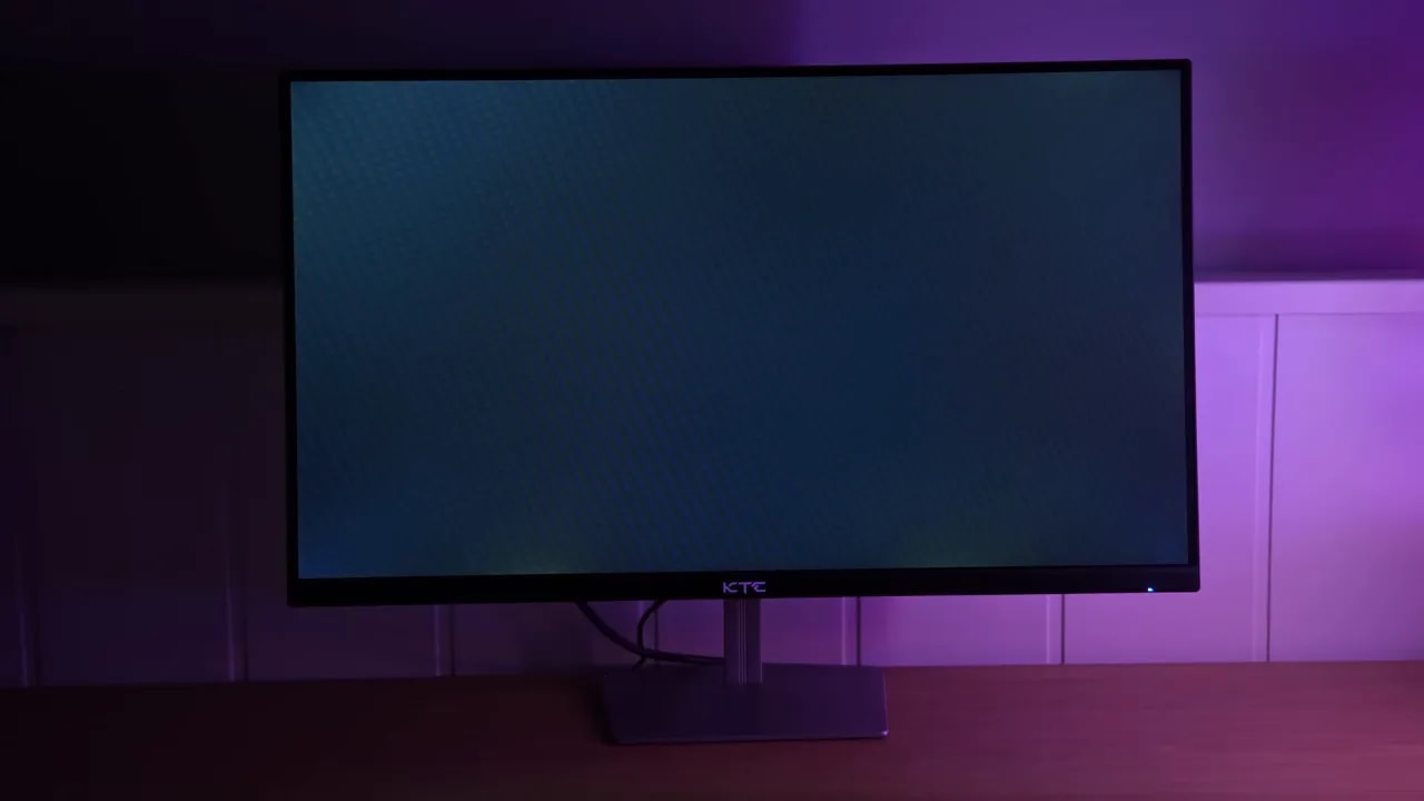 Monitor KTC H25X7 encendido en escritorio con iluminación ambiental, mostrando posible uniformidad irregular y fugas de luz