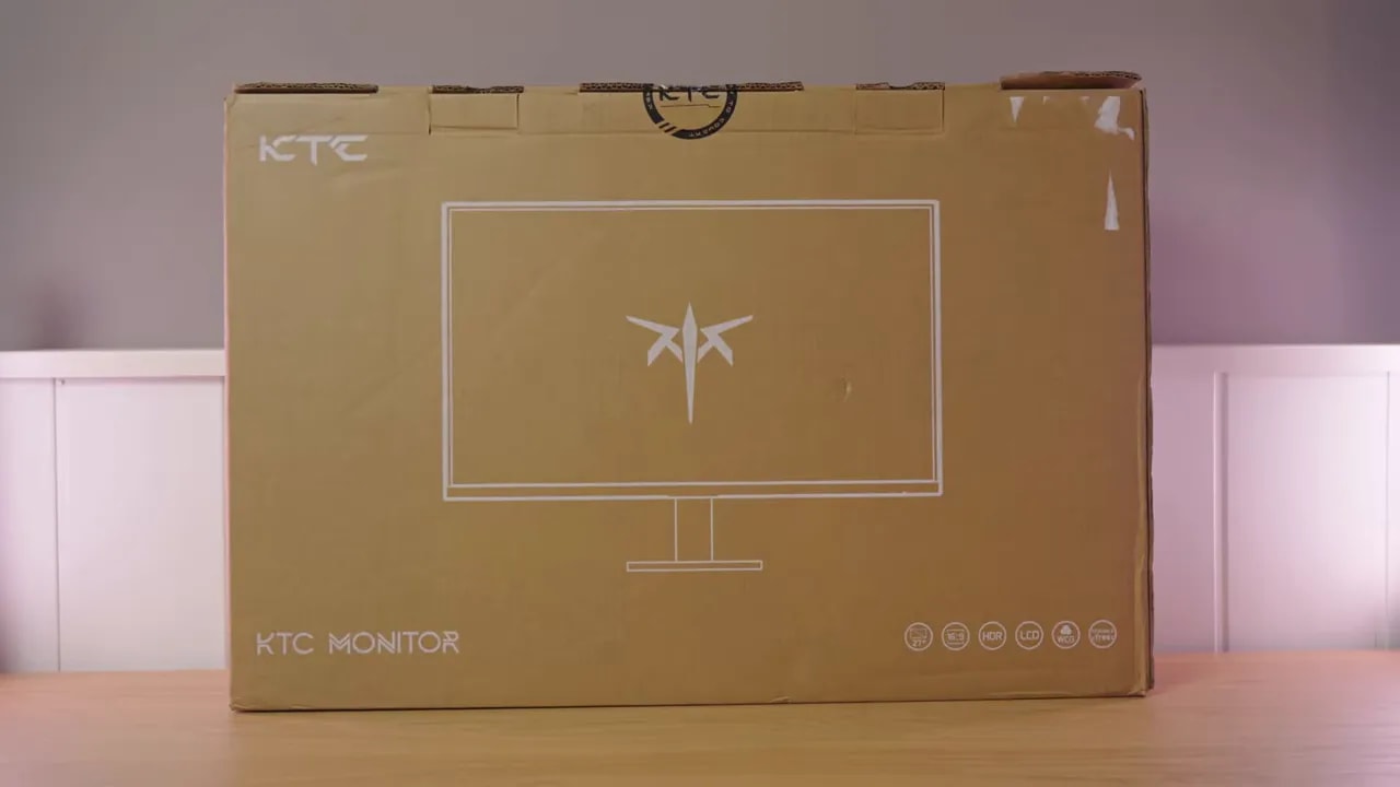 Manos revisando los papeles y guías de instalación del monitor KTC H27T27 dentro de la caja