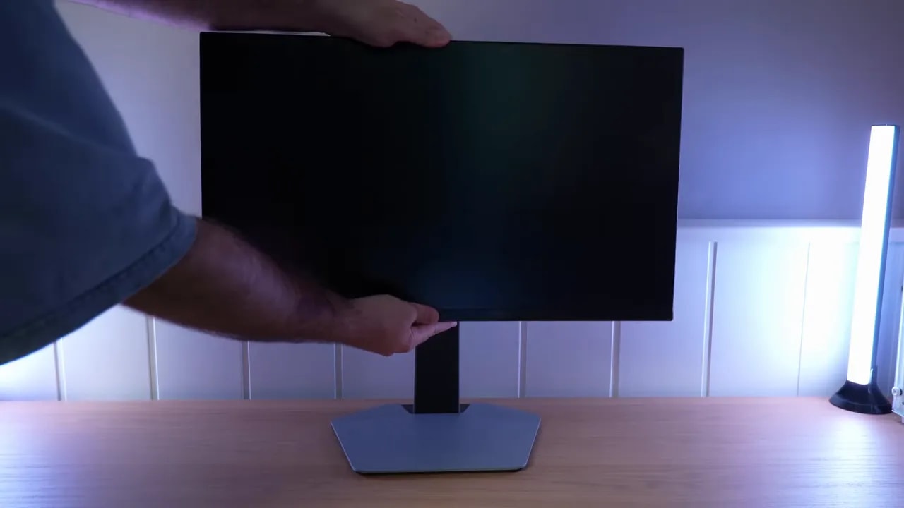 Monitor TCL 25G64 colocado en el escritorio sobre su peana mientras se muestra el montaje